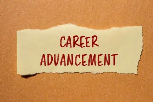 Career advancement message written on ripped paper piece with cardboard background.