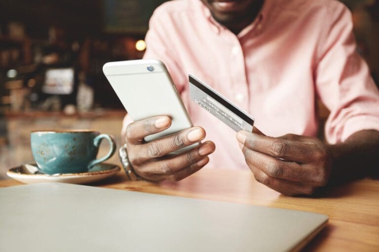 Man in Casual Shirt Paying With Credit Card Online