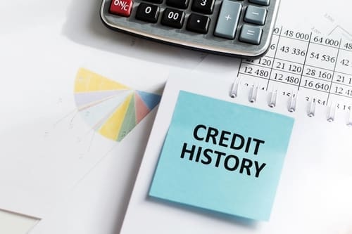 CREDIT HISTORY on a blue card in front of an office desk.