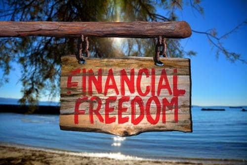 Financial freedom motivational phrase sign on old wood with blurred background
